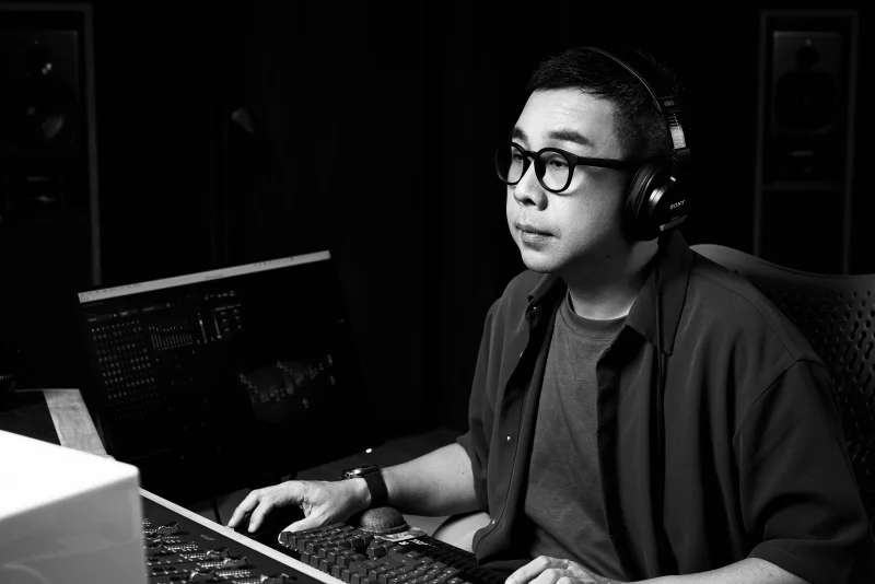 Micky Yang working at the mixing console in his studio